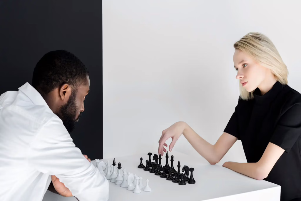zukunft des schachtrainings multicultural couple playing chess near black and white